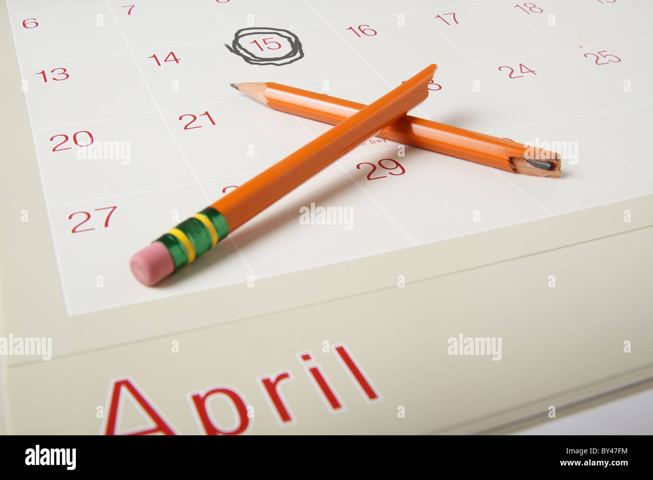 Foto del desktop con un calendario che mostra aprile xv cerchiato e la rottura di una matita che simbolizza la frustrazione con imposte sul reddito. Foto Stock