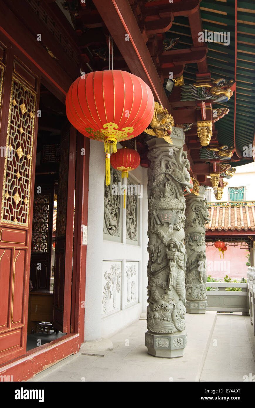 Lanterna rossa appesa sopra un muro di pietra e porta di legno nel Tempio Kaiyuan, Quanzhou. Foto Stock