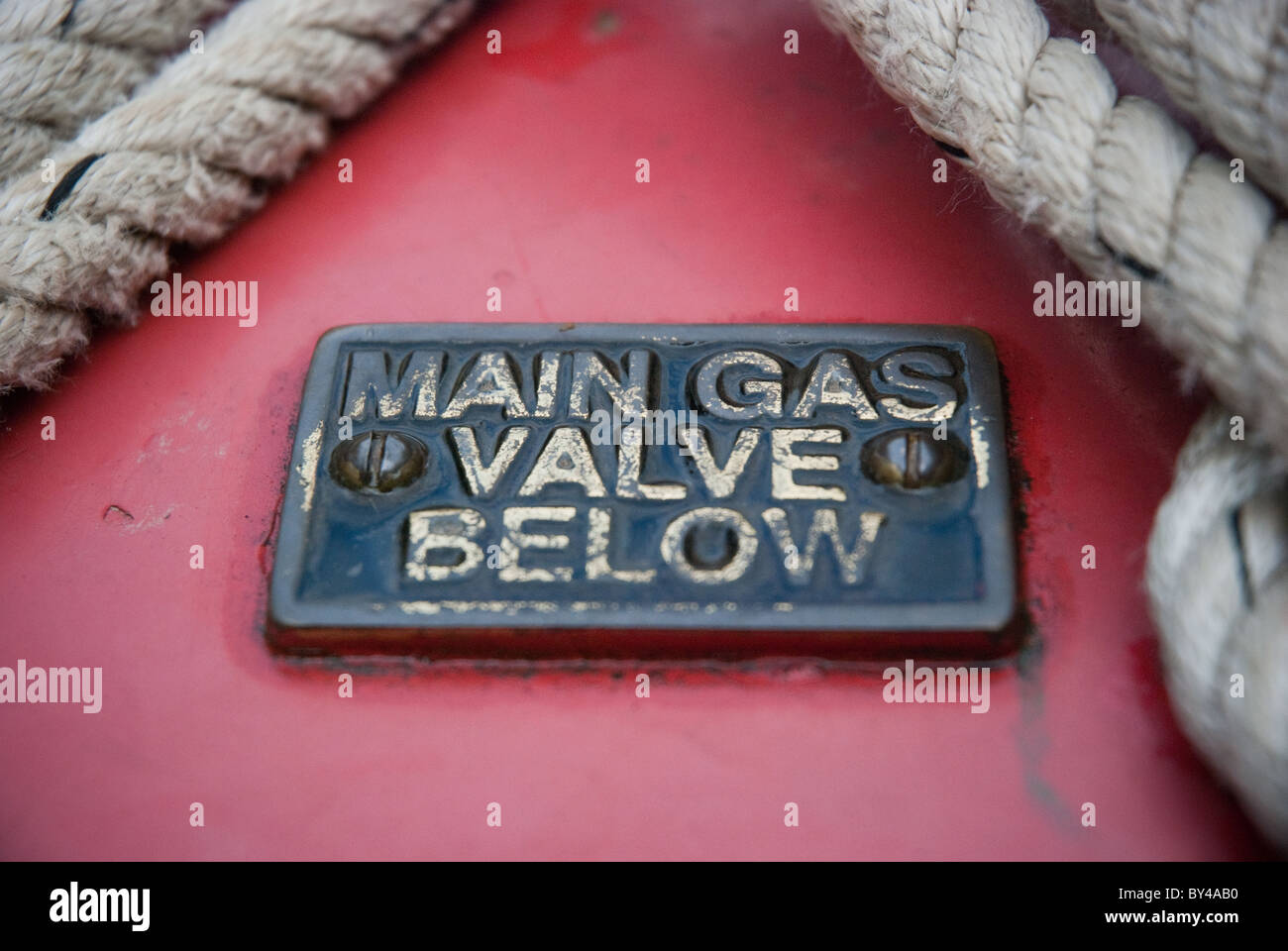 Un segno di ottone su un narrowboat indicando principale della valvola a gas al di sotto di Foto Stock