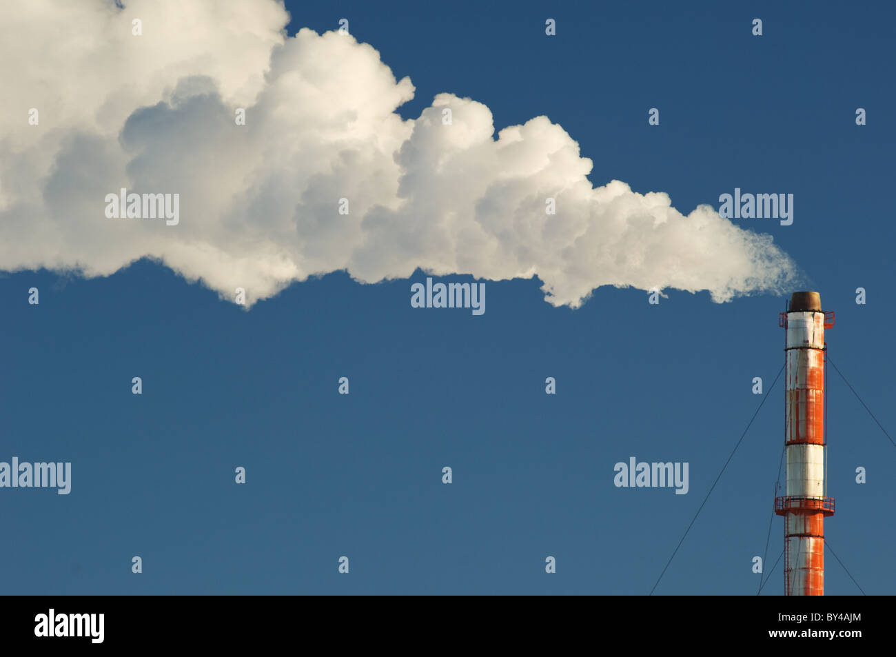 Di fumo, gas e vapore flutti di un fumaiolo contro un cielo blu. Foto Stock