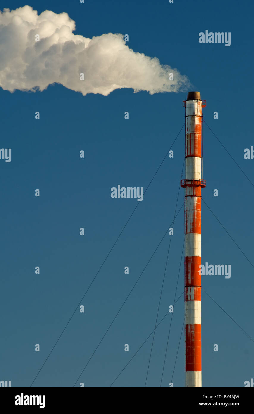 Di fumo, gas e vapore flutti di un fumaiolo contro un cielo blu. Foto Stock