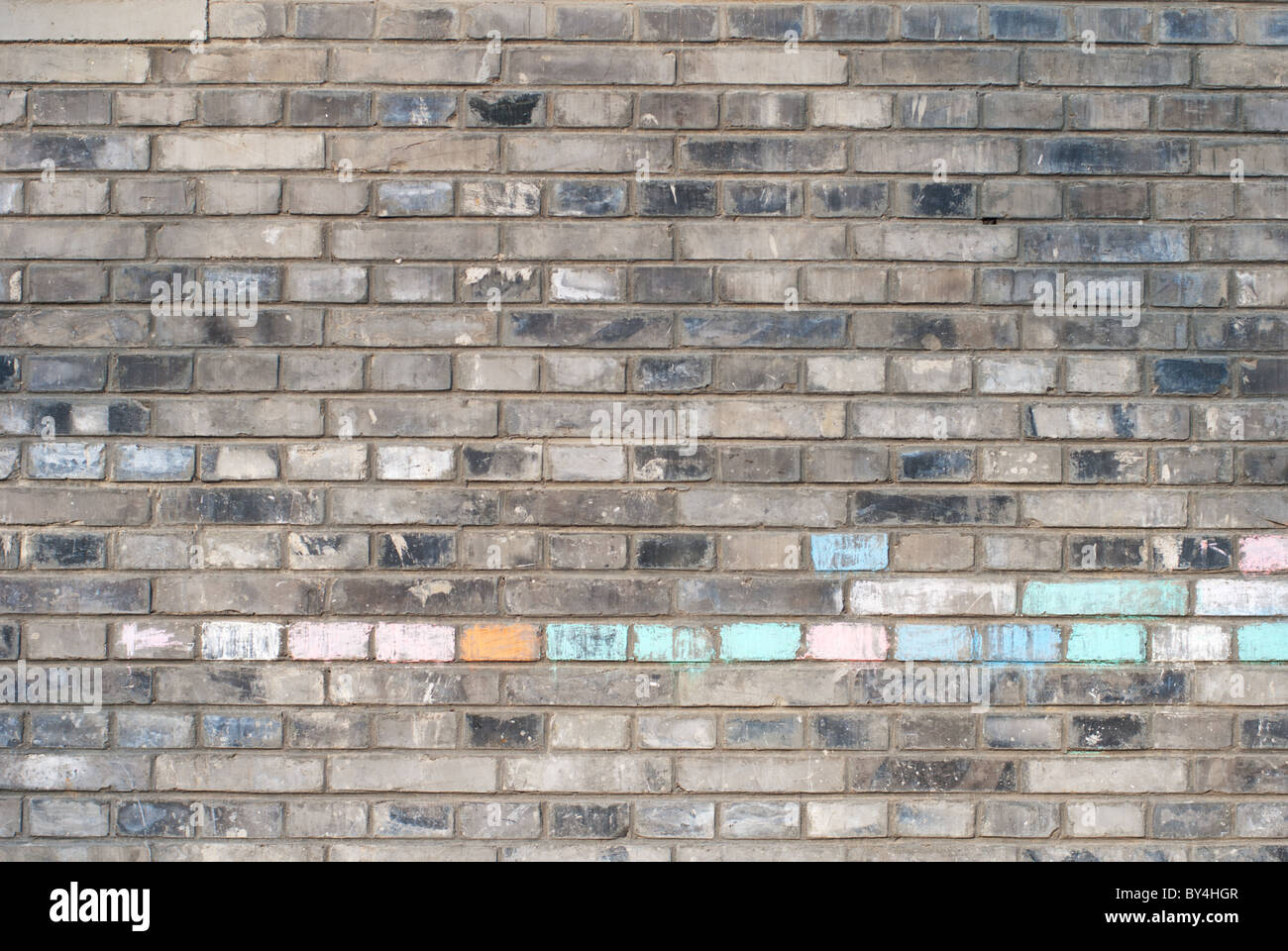 Grigio a muro in mattoni con alcuni mattoni colorati con i gessi Foto Stock