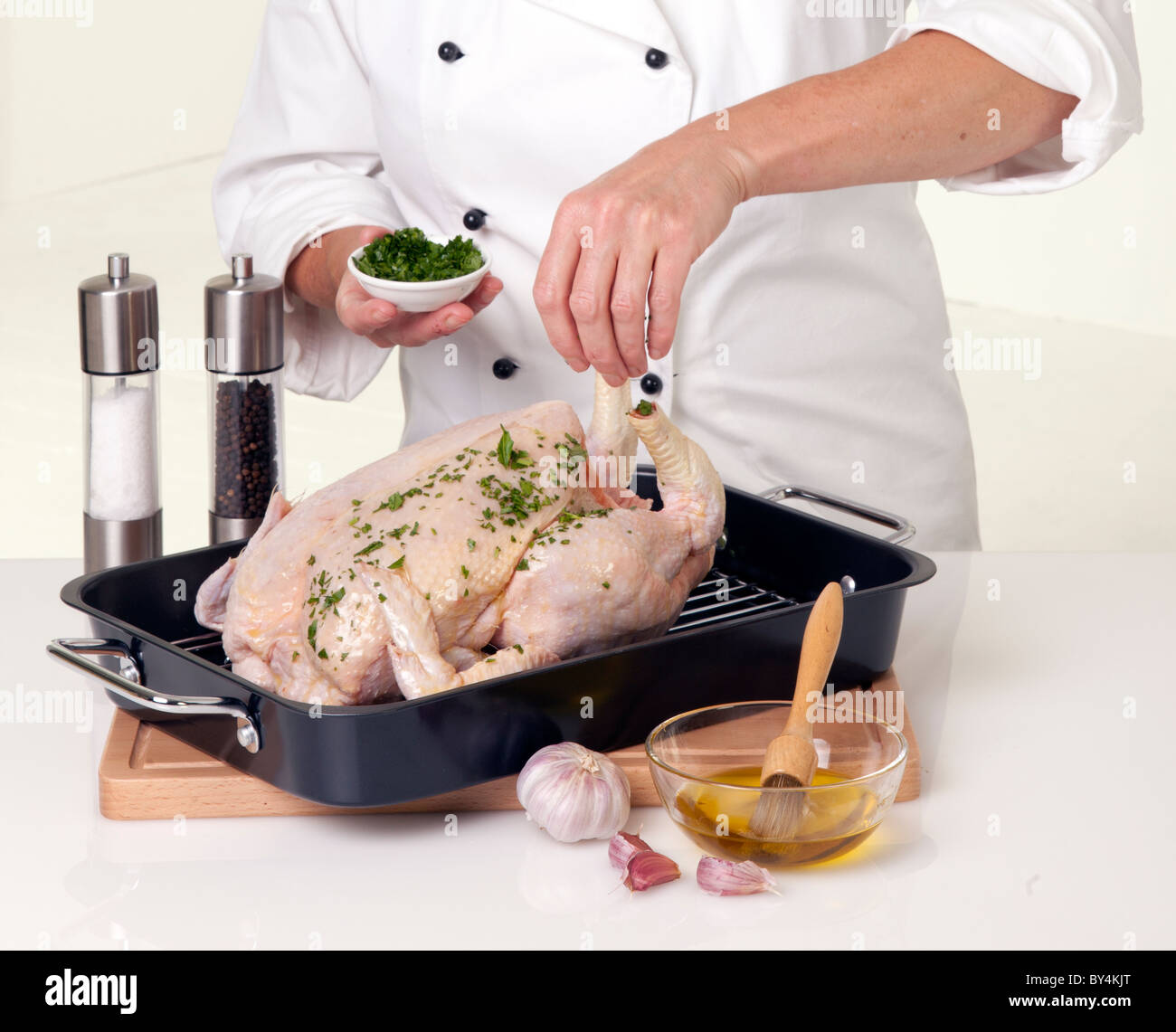Lo chef condimento di pollo intero per la tostatura Foto Stock
