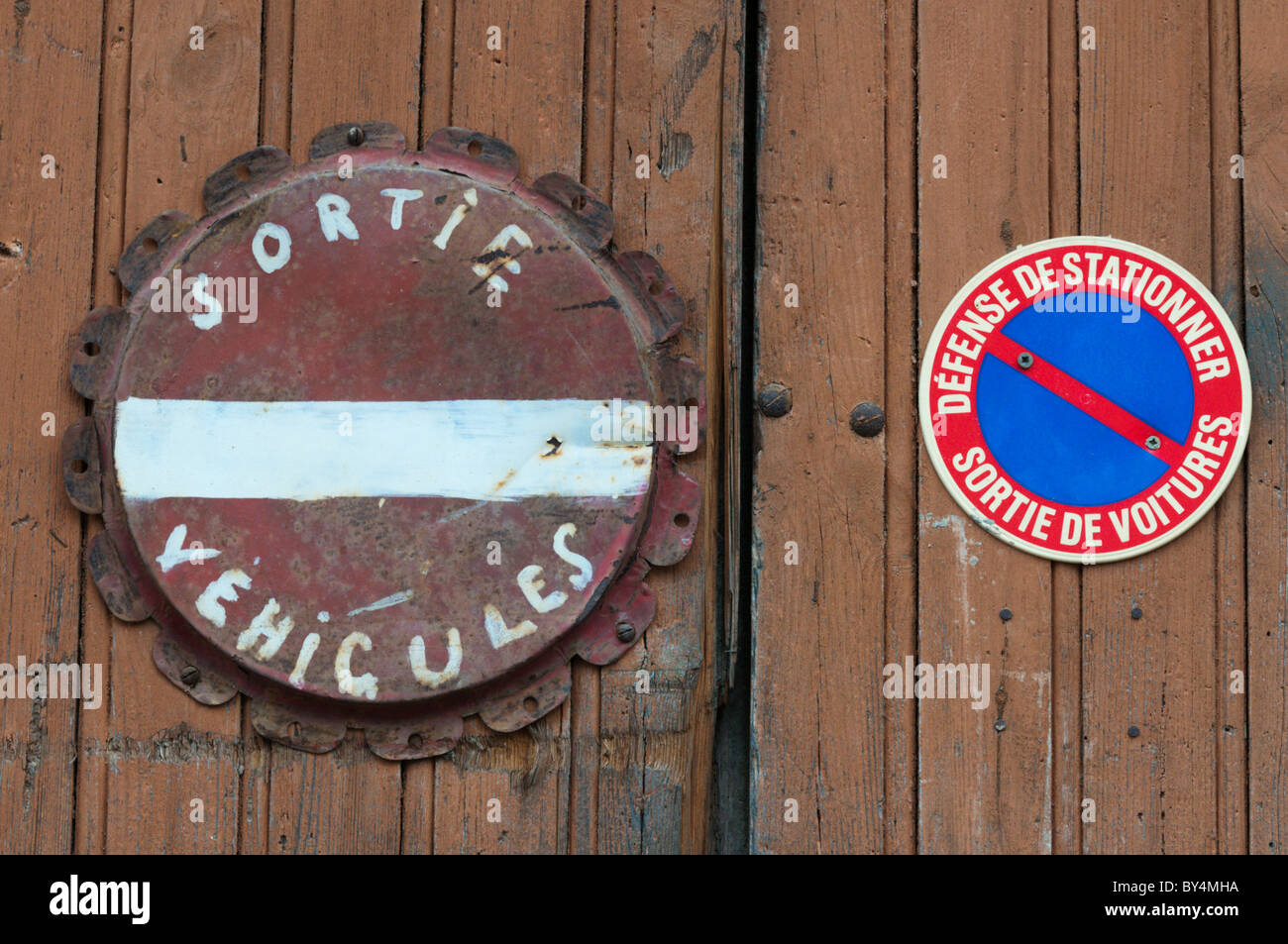 Il francese "Veicolo Exit' e 'No parcheggio' segni su una porta di garage in un villaggio francese. Foto Stock