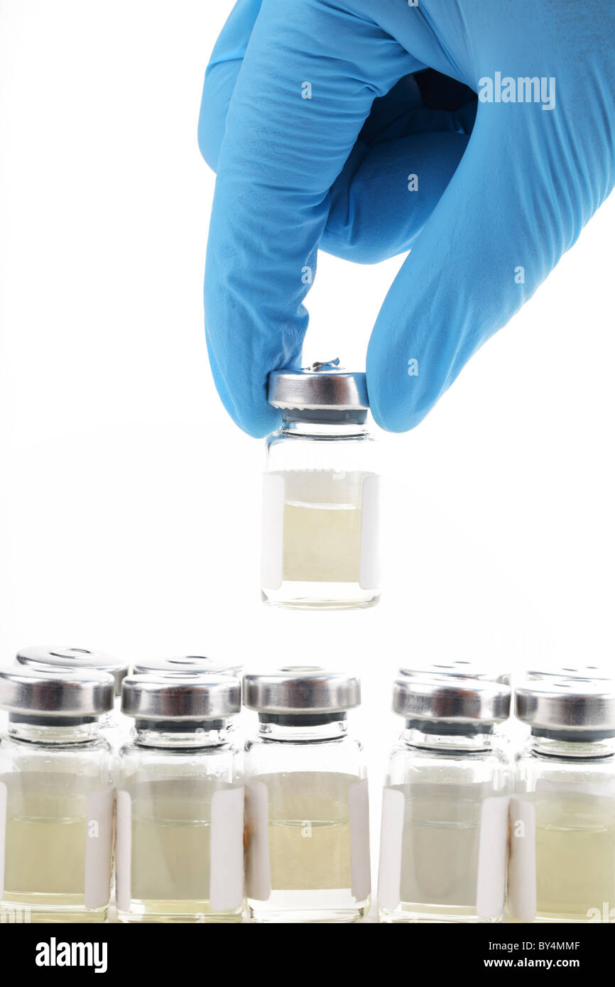 Medico la mano che tiene la bottiglia con la medicina su sfondo bianco Foto Stock