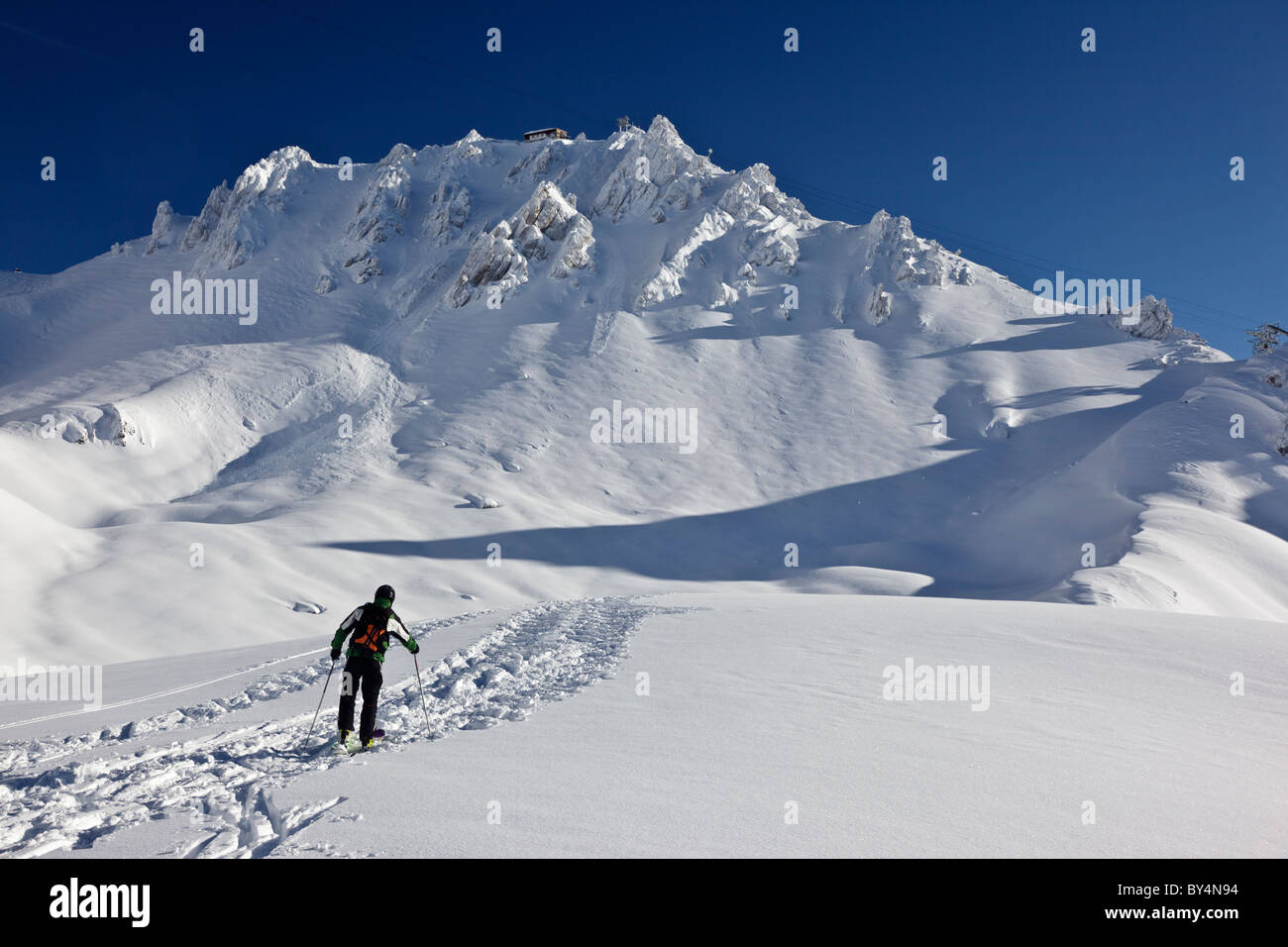 Uno sciatore, con apparecchiature moderne ed e fuori-pista di marcia nella parte anteriore delle maestose cime di St Anton in Austria Foto Stock