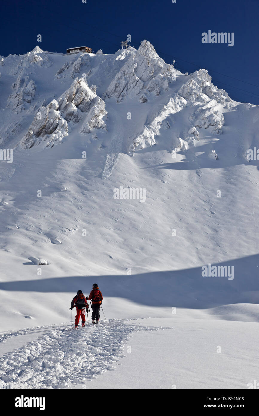 Due gli sciatori, con apparecchiature moderne, caschi e fuori pista dentata, pausa nella parte anteriore delle maestose cime di St Anton in Austria Foto Stock