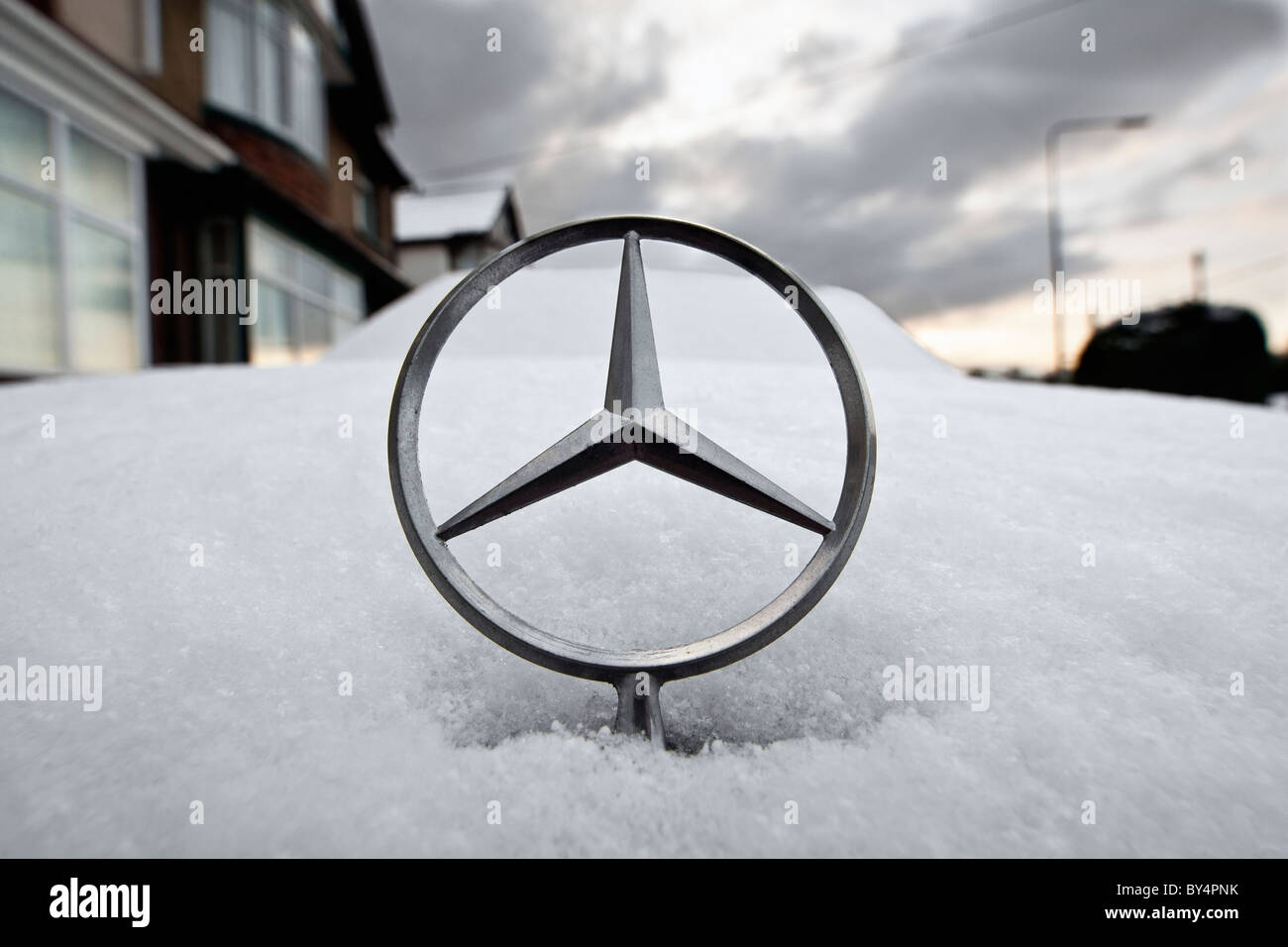 Una Mercedes cofano / cappa star è fotografato su una coperta di neve Mercedes vettura dopo le tempeste di neve ha colpito il Regno Unito. Foto Stock