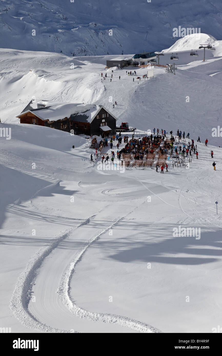 Gli sciatori e gli snowboarder fermarsi per una sosta al famoso Ulmer Hutte in St Anton. La seggiovia Valfagehr è in distanza. Foto Stock