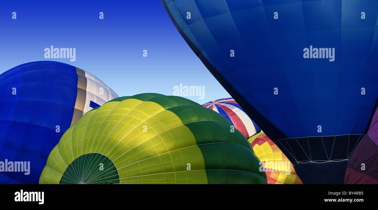 Colorate mongolfiere parzialmente gonfiato su una luminosa mattina di sole Foto Stock