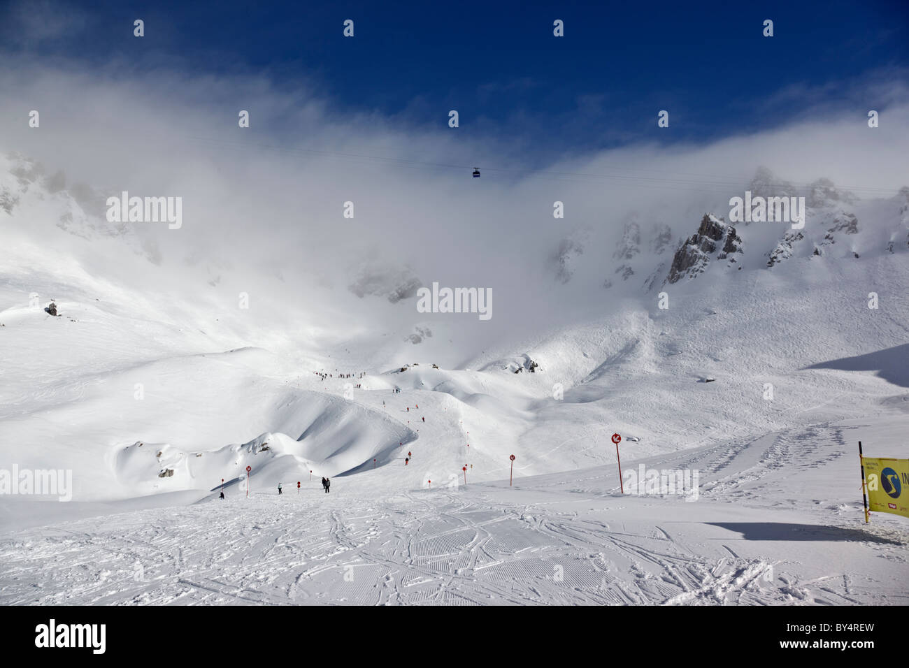 Gli sciatori e gli snowboarder pista discendente 14 dalla causa Schindler Spitze al Ulmer Hutte in St Anton am Arlberg. Foto Stock