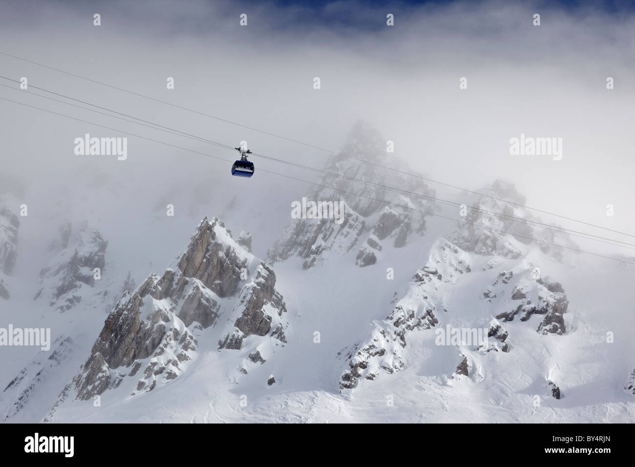 Vista in lontananza il blu Valuga funivia salendo attraverso la nebbia da Galzig verso la stazione di Valugagrat a 2650m Foto Stock