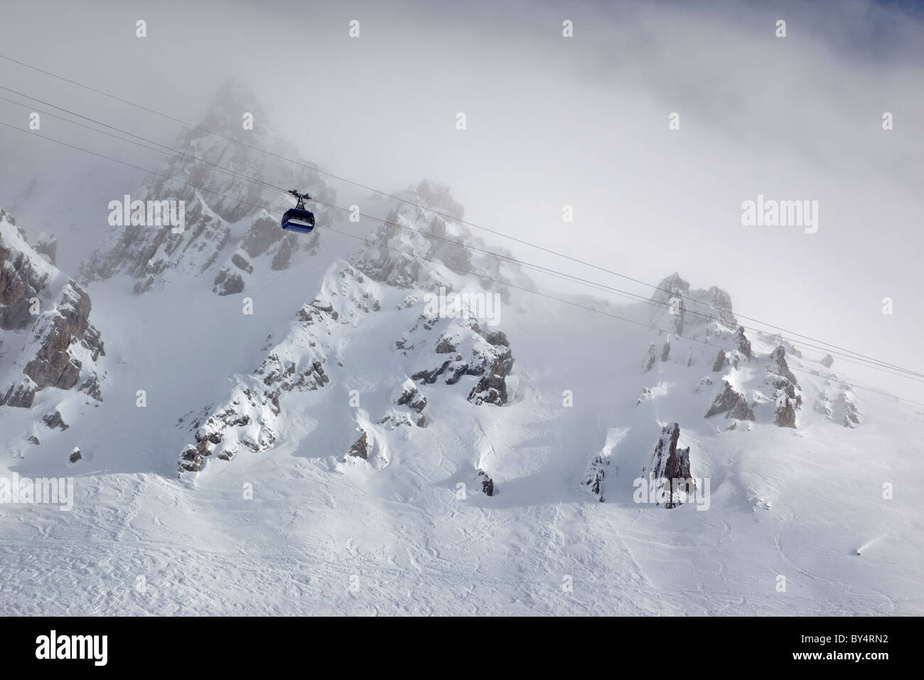 Vista in lontananza il blu Valuga funivia salendo attraverso la nebbia da Galzig verso la stazione di Valugagrat a 2650m Foto Stock