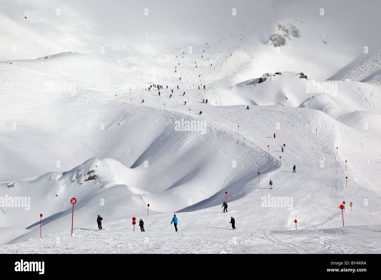 Gli sciatori e gli snowboarder pista discendente 14 dalla causa Schindler Spitze al Ulmer Hutte in St Anton am Arlberg. Foto Stock