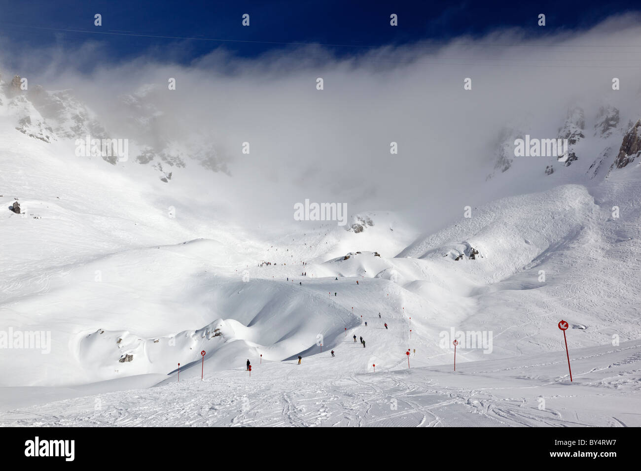 Gli sciatori e gli snowboarder pista discendente 14 dalla causa Schindler Spitze al Ulmer Hutte in St Anton am Arlberg. Foto Stock