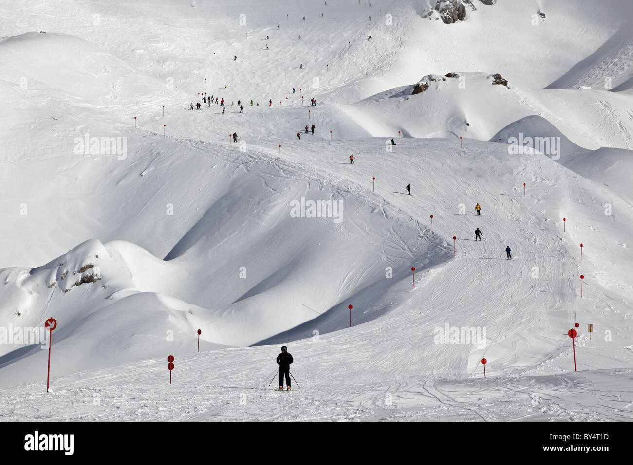 Gli sciatori e gli snowboarder pista discendente 14 dalla causa Schindler Spitze al Ulmer Hutte in St Anton am Arlberg. Foto Stock