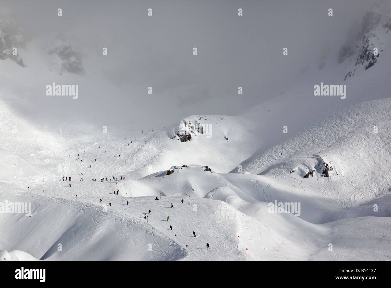 Gli sciatori e gli snowboarder pista discendente 14 attraverso la nebbia dalla causa Schindler Spitze al Ulmer Hutte in St Anton am Arlberg. Foto Stock