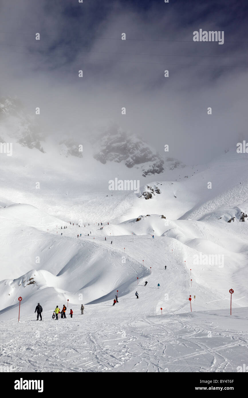 Gli sciatori e gli snowboarder pista discendente 14 dalla causa Schindler Spitze al Ulmer Hutte in St Anton am Arlberg Foto Stock
