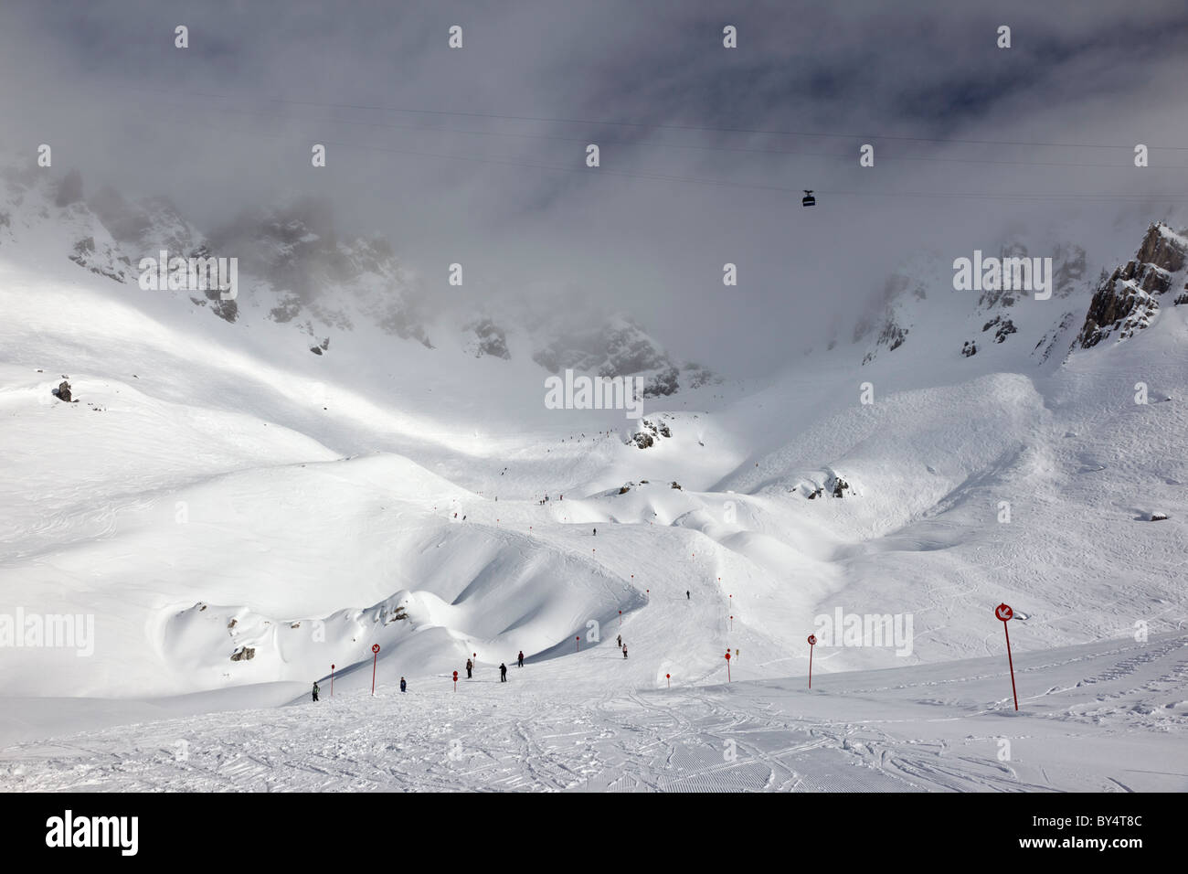Il Valuga funivia al di sopra di un sciatori piste discendente 14 dalla causa Schindler Spitze al Ulmer Hutte in St Anton am Arlberg Foto Stock