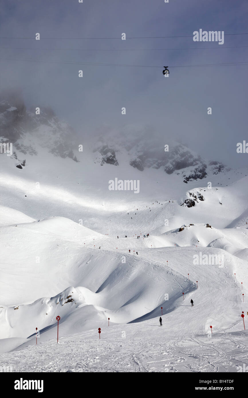 Il Valuga funivia al di sopra di un sciatori piste discendente 14 dalla causa Schindler Spitze al Ulmer Hutte in St Anton am Arlberg Foto Stock