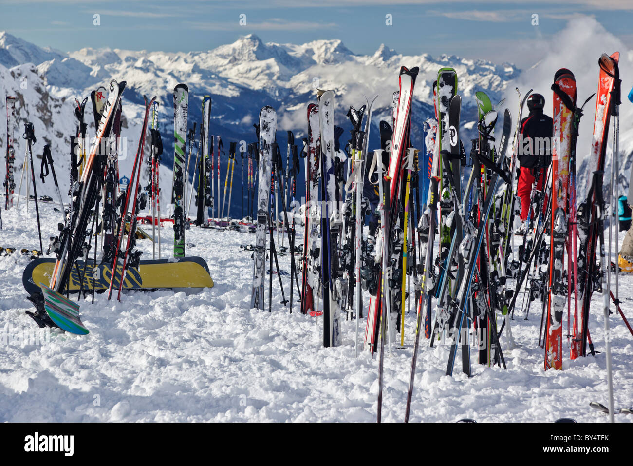 Sci e snowboard al di fuori di un ristorante di montagna con uno sfondo di montagne coperte di neve Foto Stock