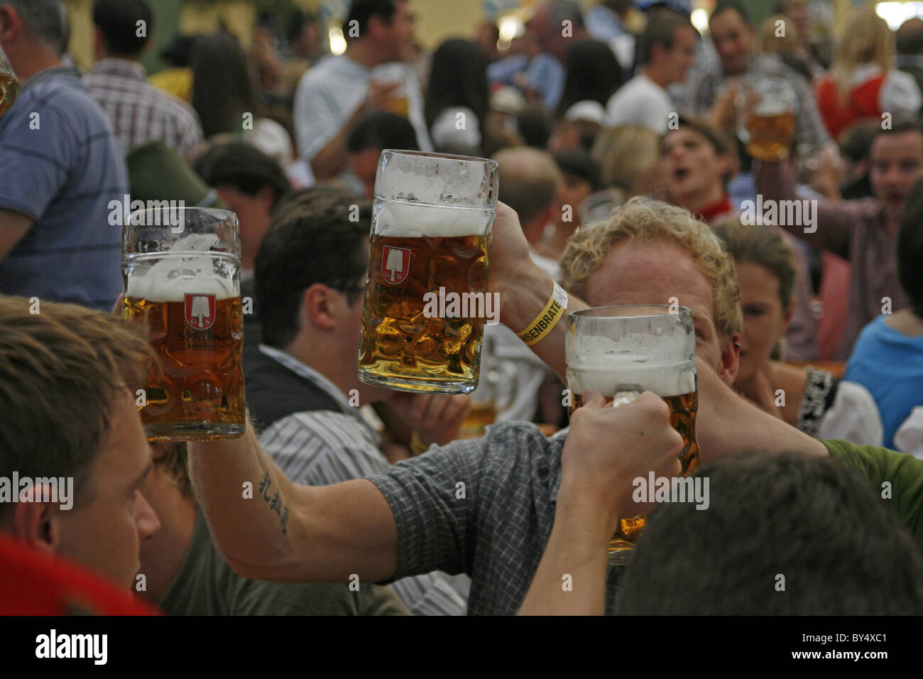 Germania Baviera Monaco di Baviera Oktoberfest giovani uomini Bavarian gustando una birra in un Oktoberfest beerhall Foto Stock