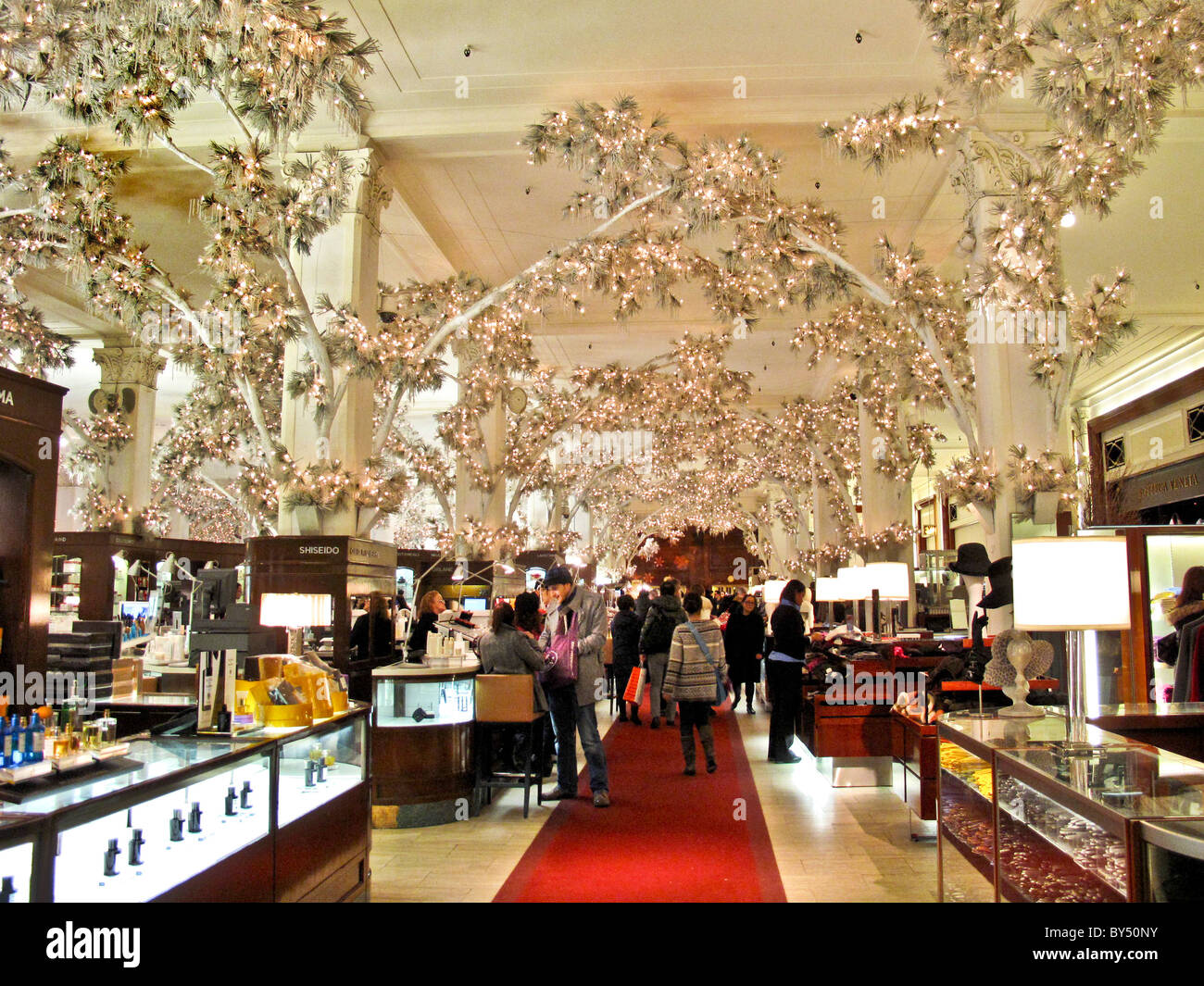 Alberi interni con elettrico acceso foglie decorare il Saks Fifth Avenue store a Natale a New York City. Foto Stock