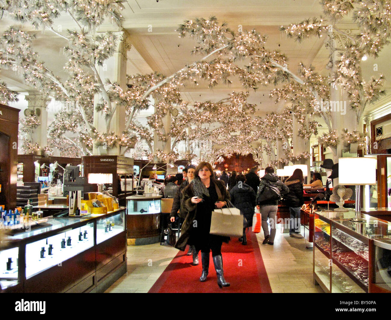 Alberi interni con elettrico acceso foglie decorare il Saks Fifth Avenue store a Natale a New York City. Foto Stock