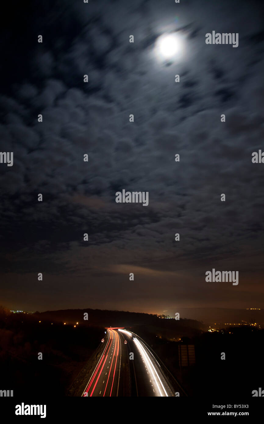 A27 a doppia carreggiata di notte con auto fari anteriori e luci di coda lasciando sentieri lungo la strada. Foto Stock