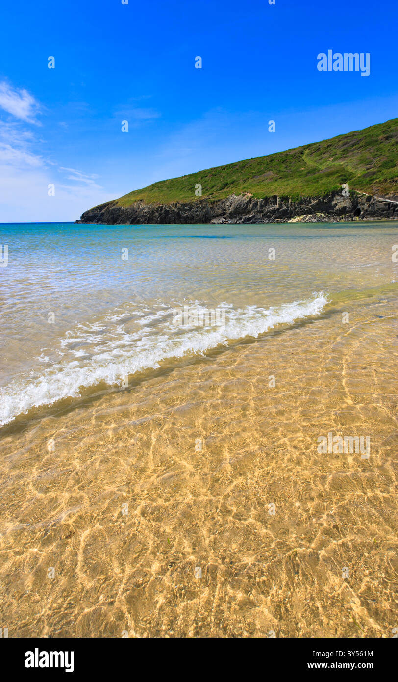Una piccola onda il lavaggio sulla spiaggia appartata a Porthcothan Bay, North Cornwall. Foto Stock