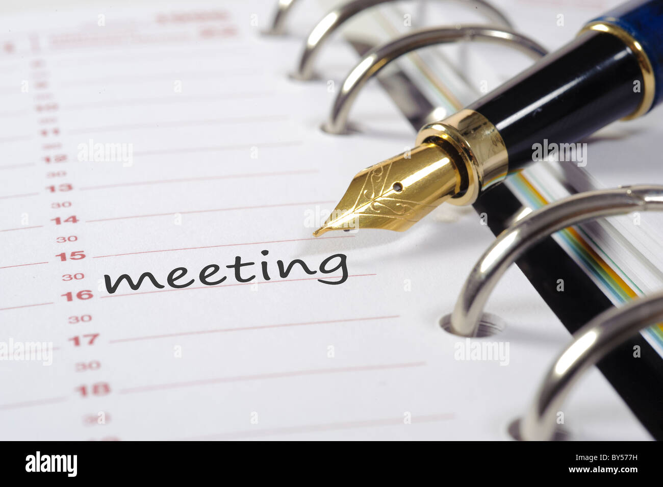 Data della riunione scritto in calendario aziendale con penna stilografica Foto Stock