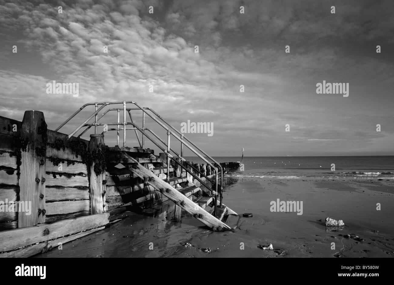 Immagine in bianco e nero di passi al di sopra di un frangiflutti sulla spiaggia a Cromer, Norfolk, Inghilterra, Regno Unito. Foto Stock