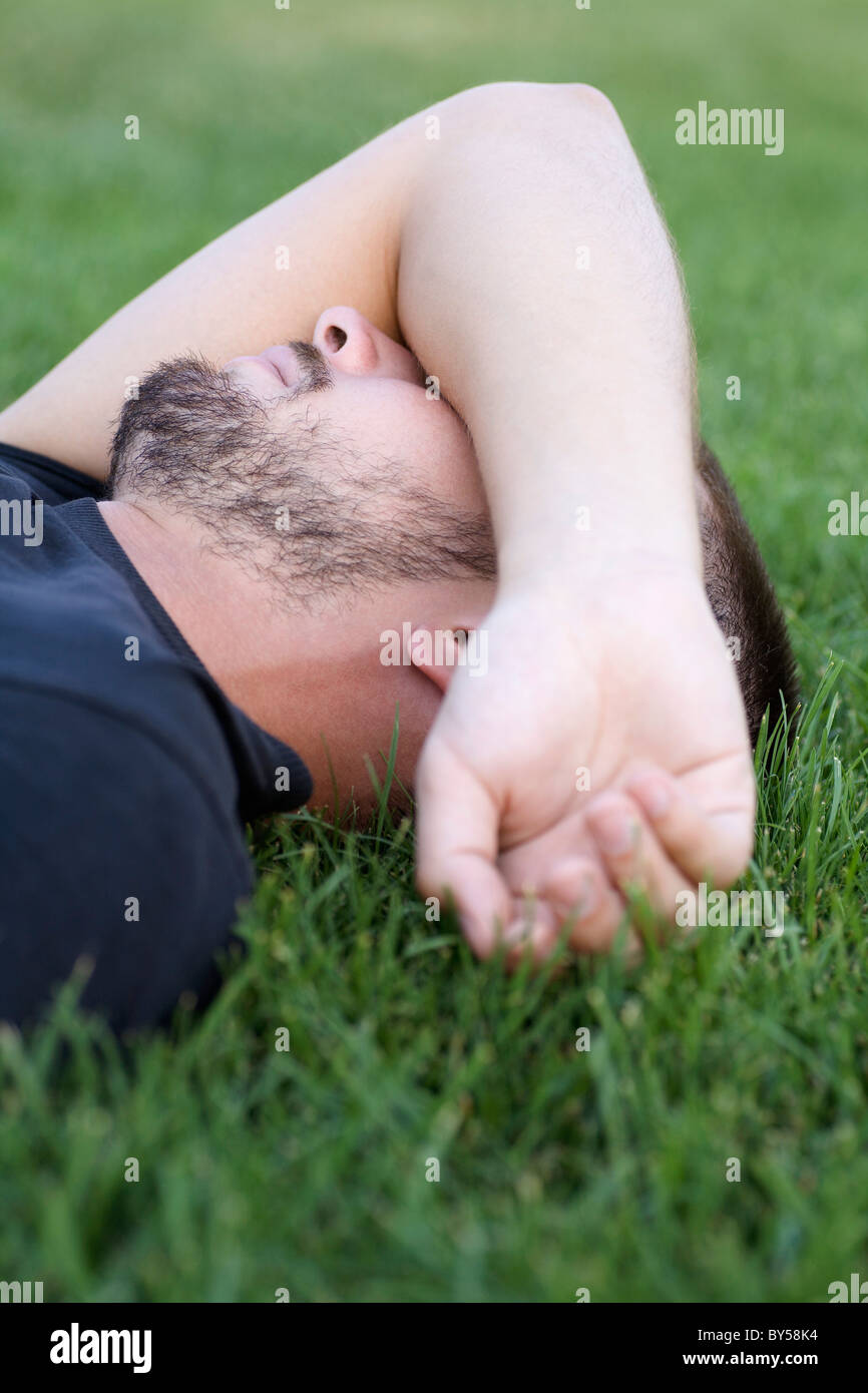 Uomo di appoggio che ricopre la faccia Foto Stock