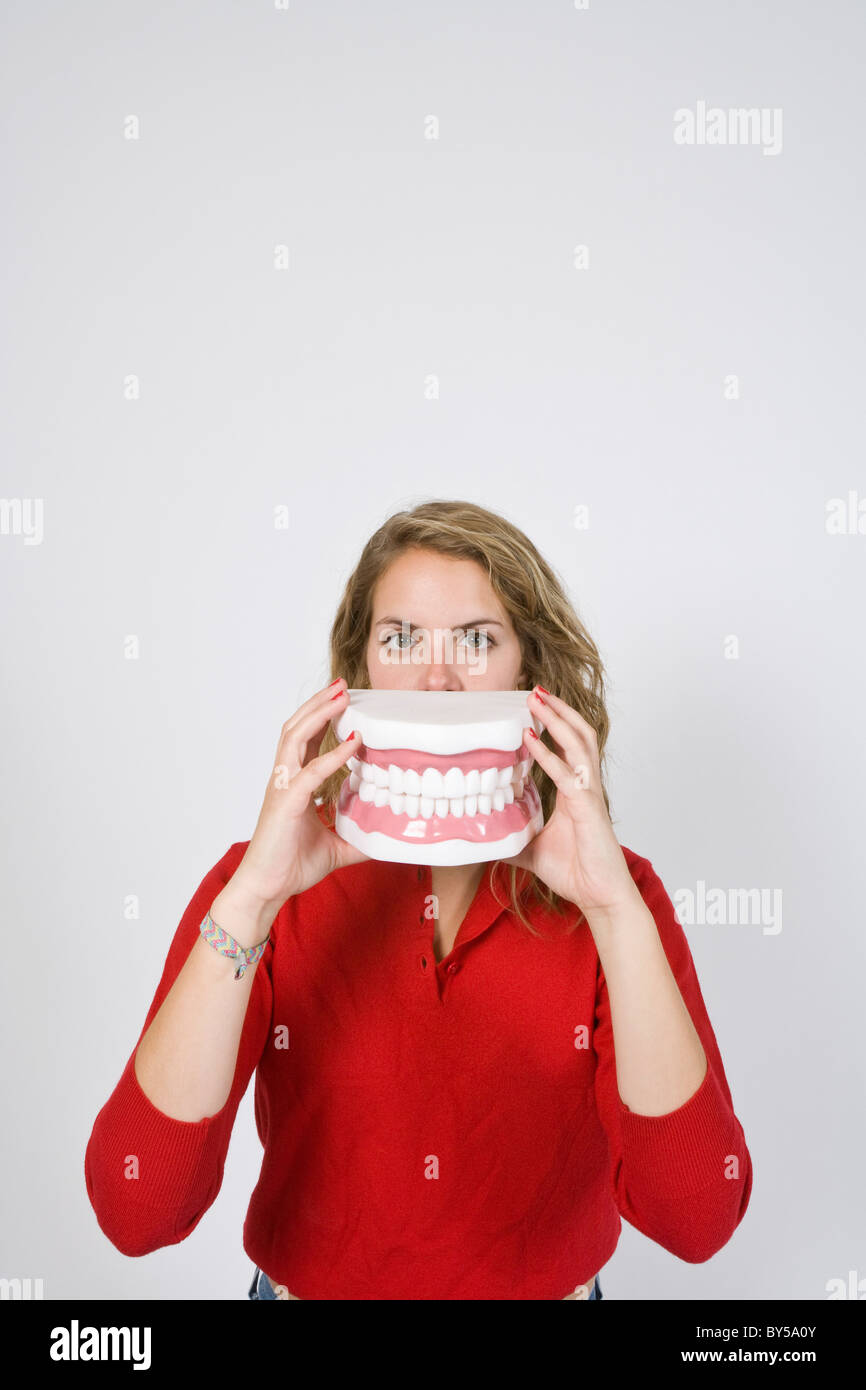 Donna che mantiene grandi denti chiusa Foto Stock