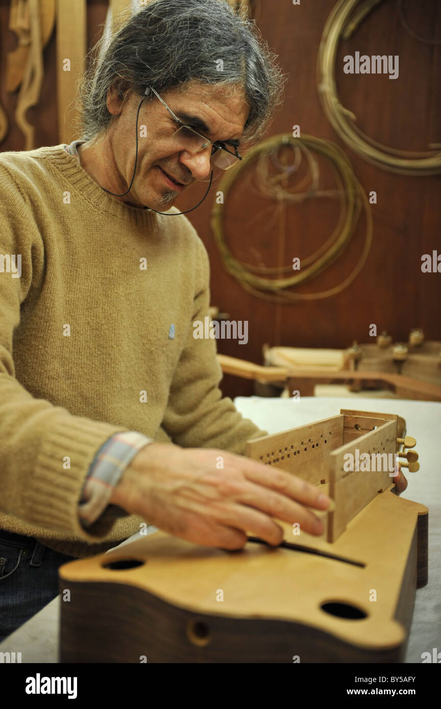 Artigiano portoghese la costruzione di una tradizionale o Sanfona concertina strumento musicale nella sua bottega, Portogallo, Europa Foto Stock