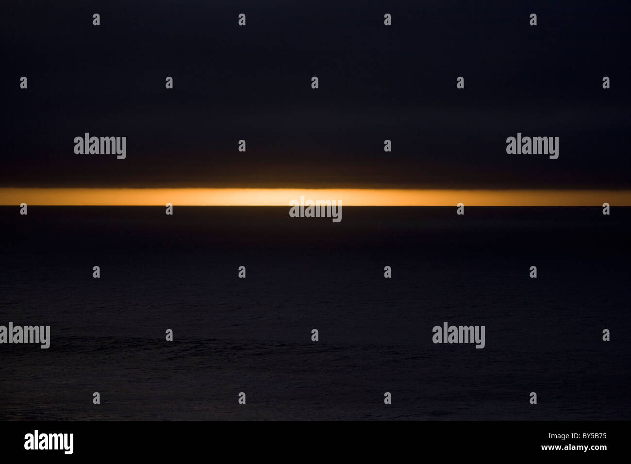 Nuvole scure sopra il mare al crepuscolo Foto Stock