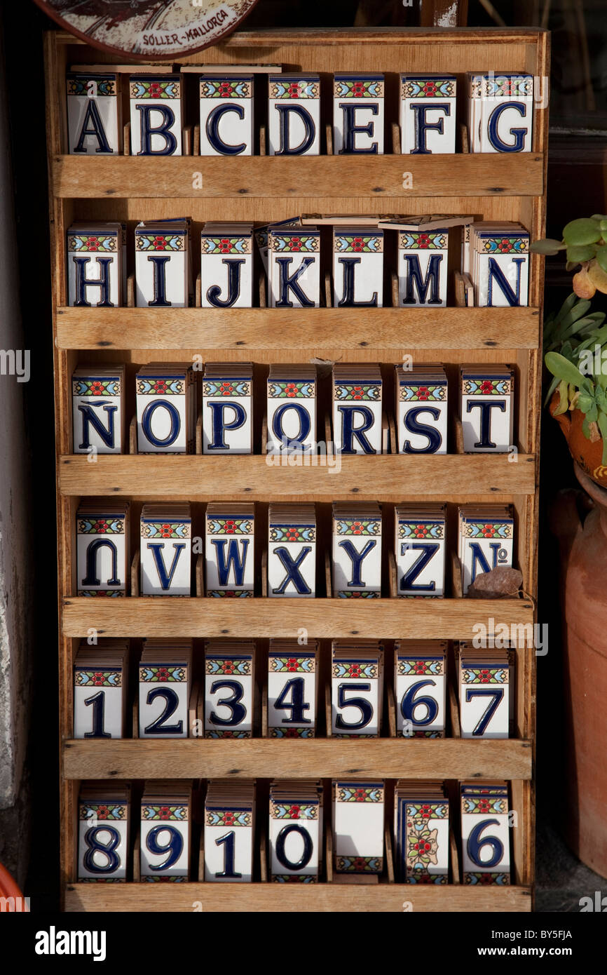 Alfabeto le lettere e i numeri riportati sulle piastrelle dipinte in vendita nel negozio di souvenir a Maiorca, SPAGNA Foto Stock