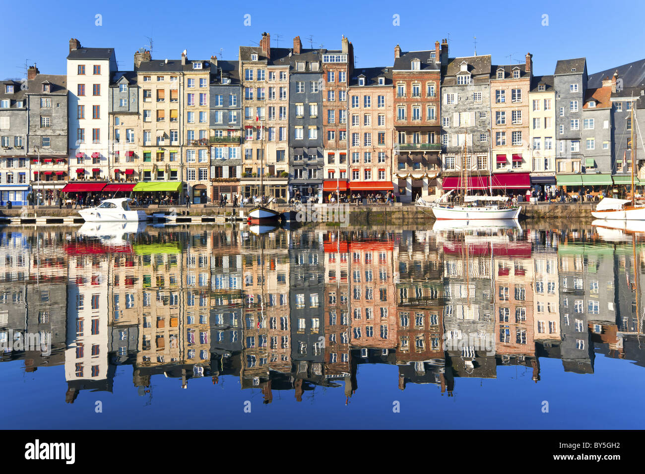 Porto di Honfleur in Normandia, Francia. Case di colore e la loro riflessione in acqua Foto Stock