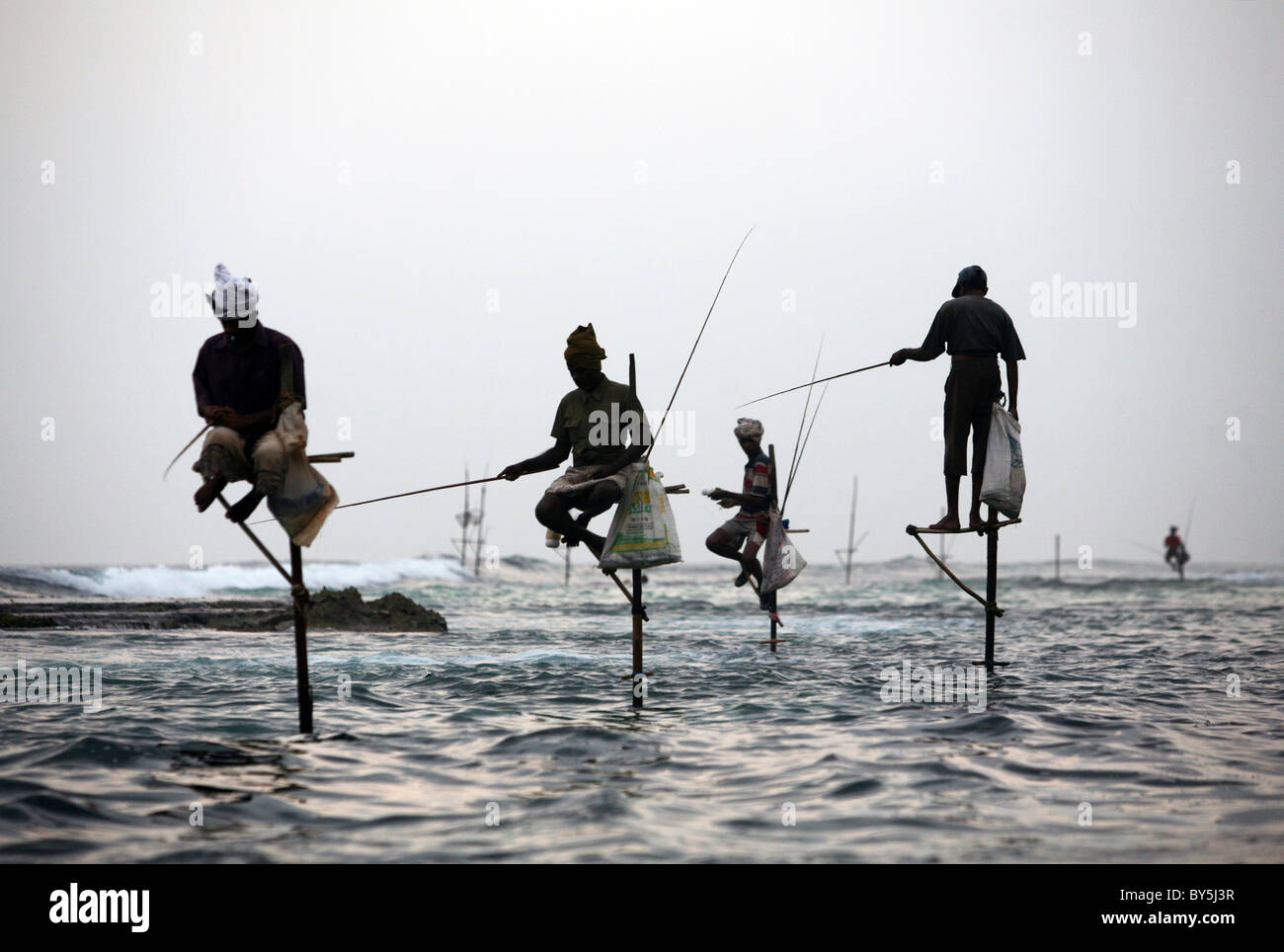 Stilt fisherman vicino a sud dello Sri Lanka città di Unawatuna. Foto Stock