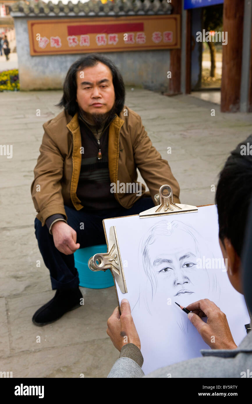 L'artista di strada facendo uno schizzo a matita di un uomo in Huanglongxi, vicino a Chengdu, nella provincia di Sichuan, in Cina. JMH4350 Foto Stock