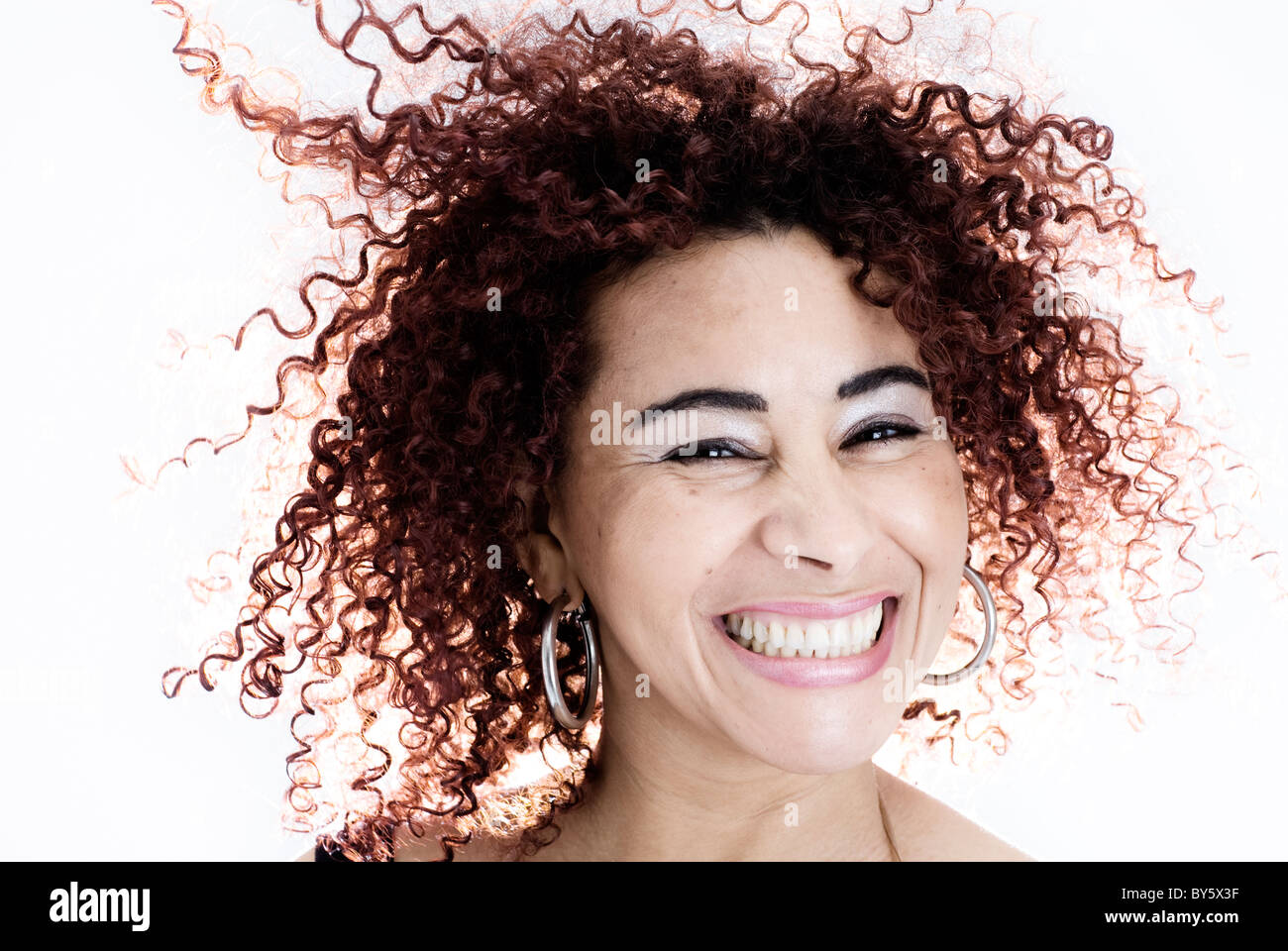 Donna brasiliana sorridendo , ha i capelli ricci e indossa un serbatoio nero top Foto Stock