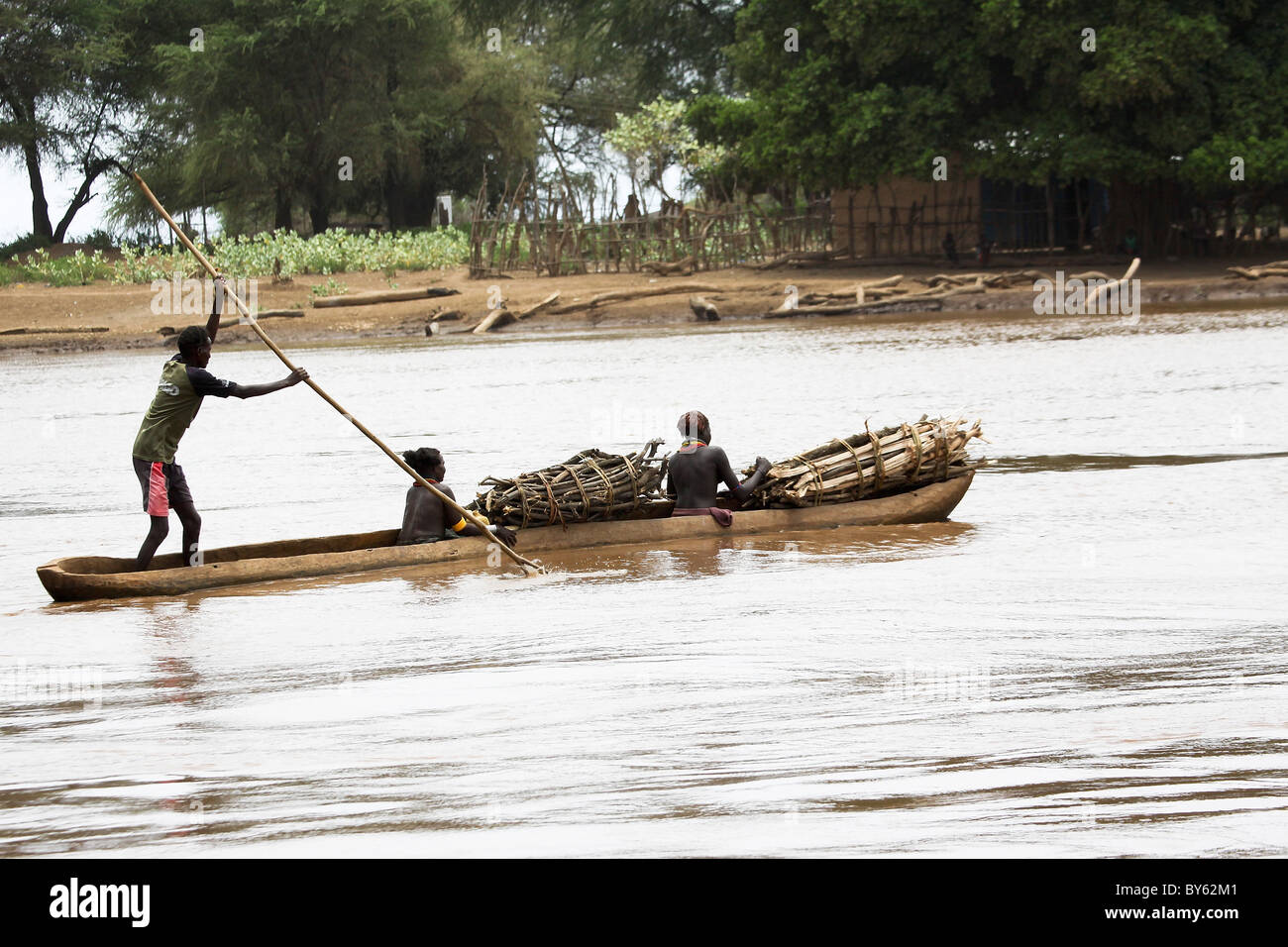 Africa, Etiopia, Valle dell'Omo, Daasanach tribù donna righe una canoa nel fiume Foto Stock