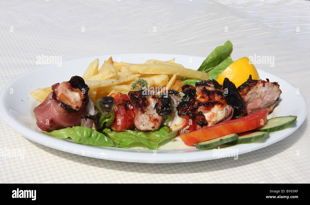 La carne di maiale Souvlaki kebab su una piastra - servita in Grecia Foto Stock