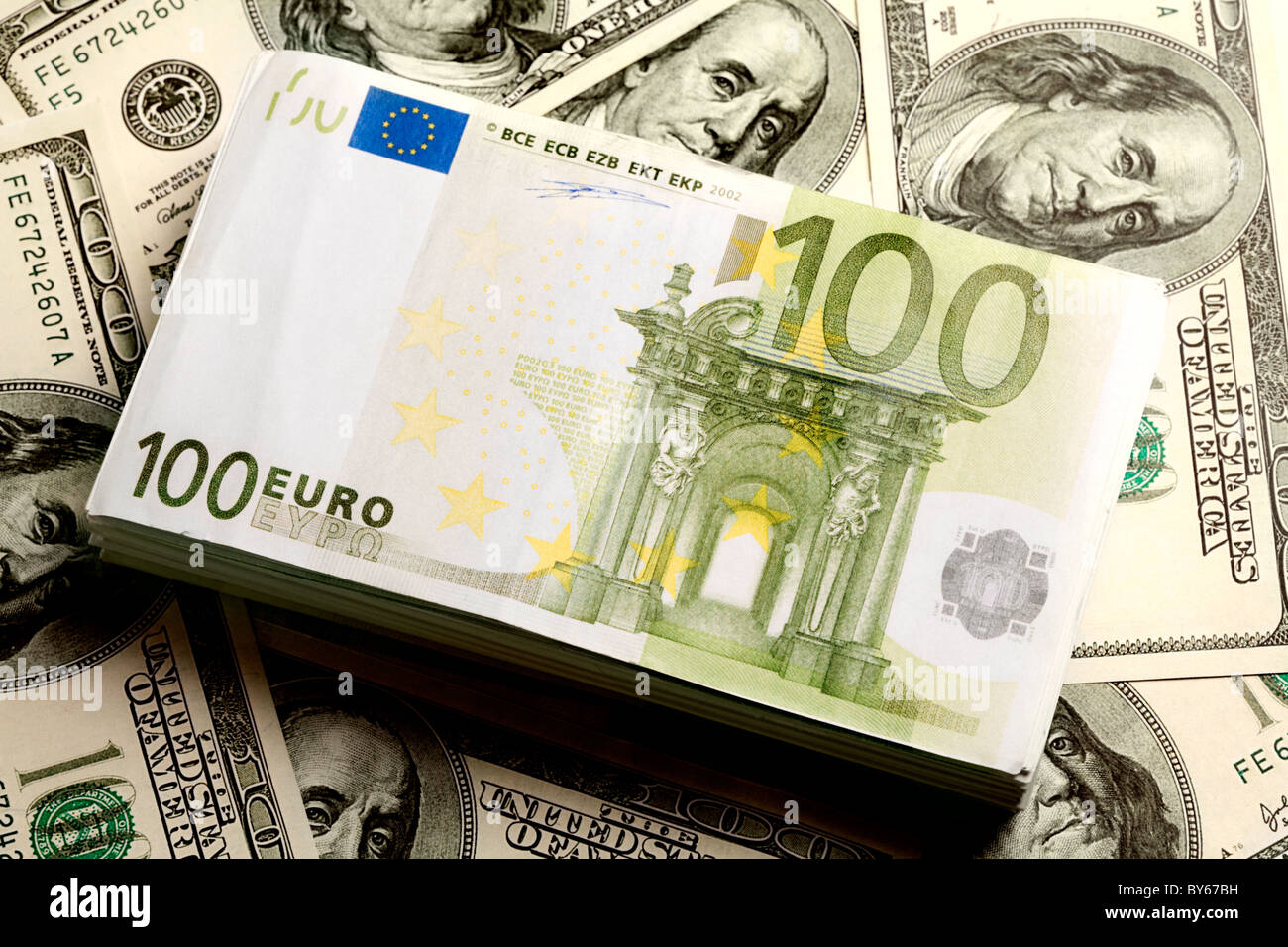 Close-up del mucchio di dollari USA con un rotolo di euro su di esso Foto Stock