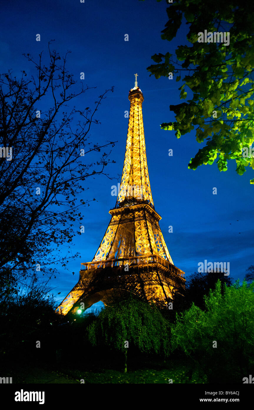 PARIGI, Francia: La Torre Eiffel si erge illuminata contro il cielo notturno della capitale francese. L'iconica struttura in ferro si illumina di luci dorate e il suo brillante display crea un faro nel paesaggio notturno parigino. Foto Stock