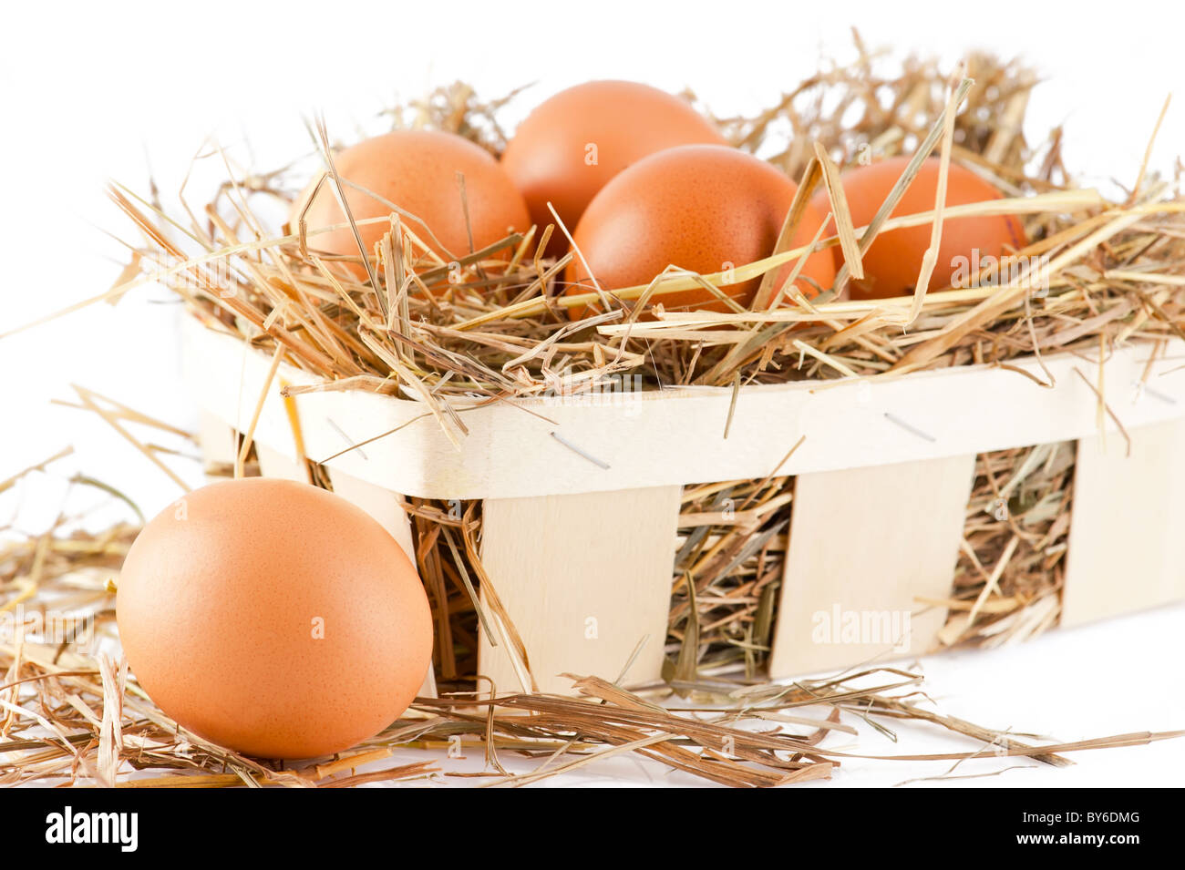 Riprese macro di marrone le uova nel paniere di legno a hay Foto Stock