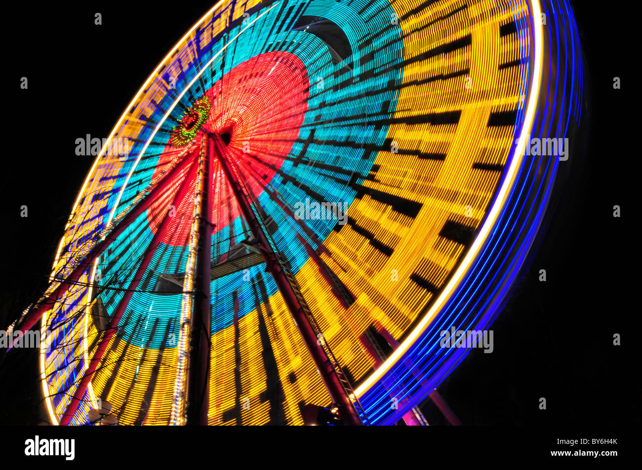 Luna park giostre di notte con percorsi di luce Foto Stock
