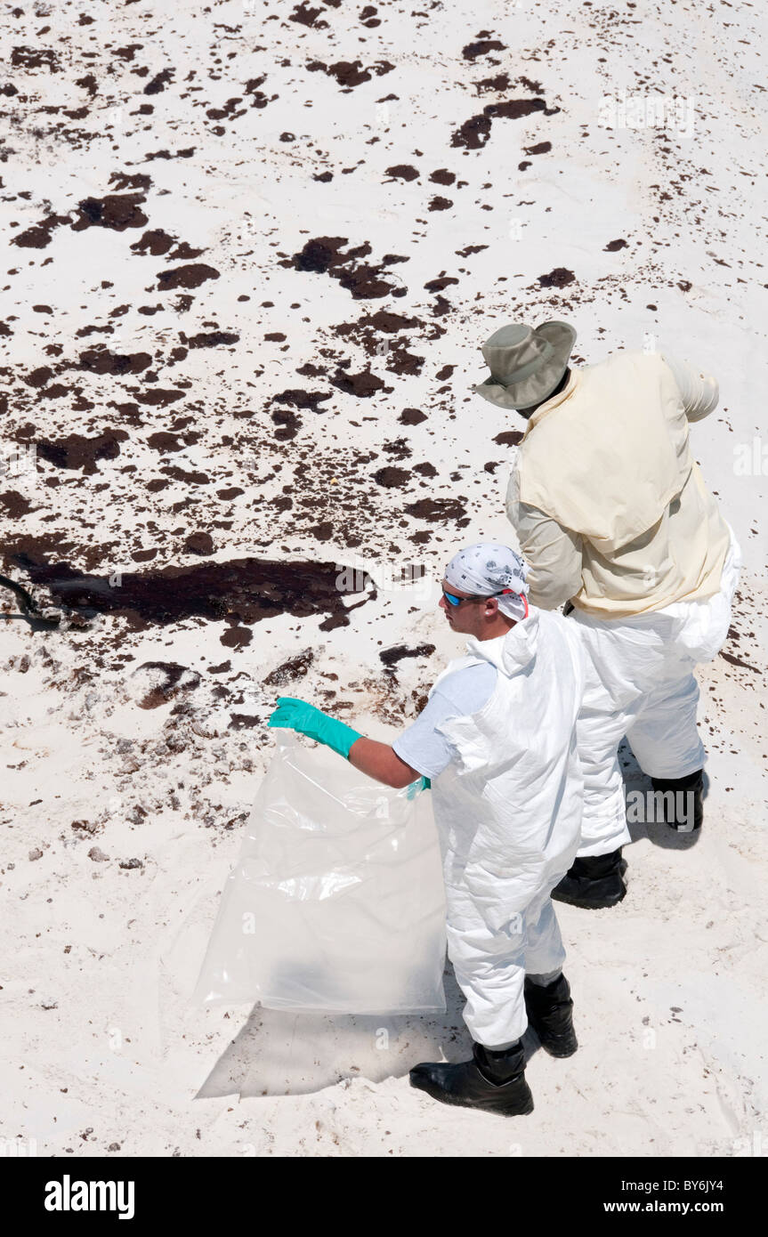 BP cleanup equipaggi provare a rimuovere l'olio dalla spiaggia Foto Stock