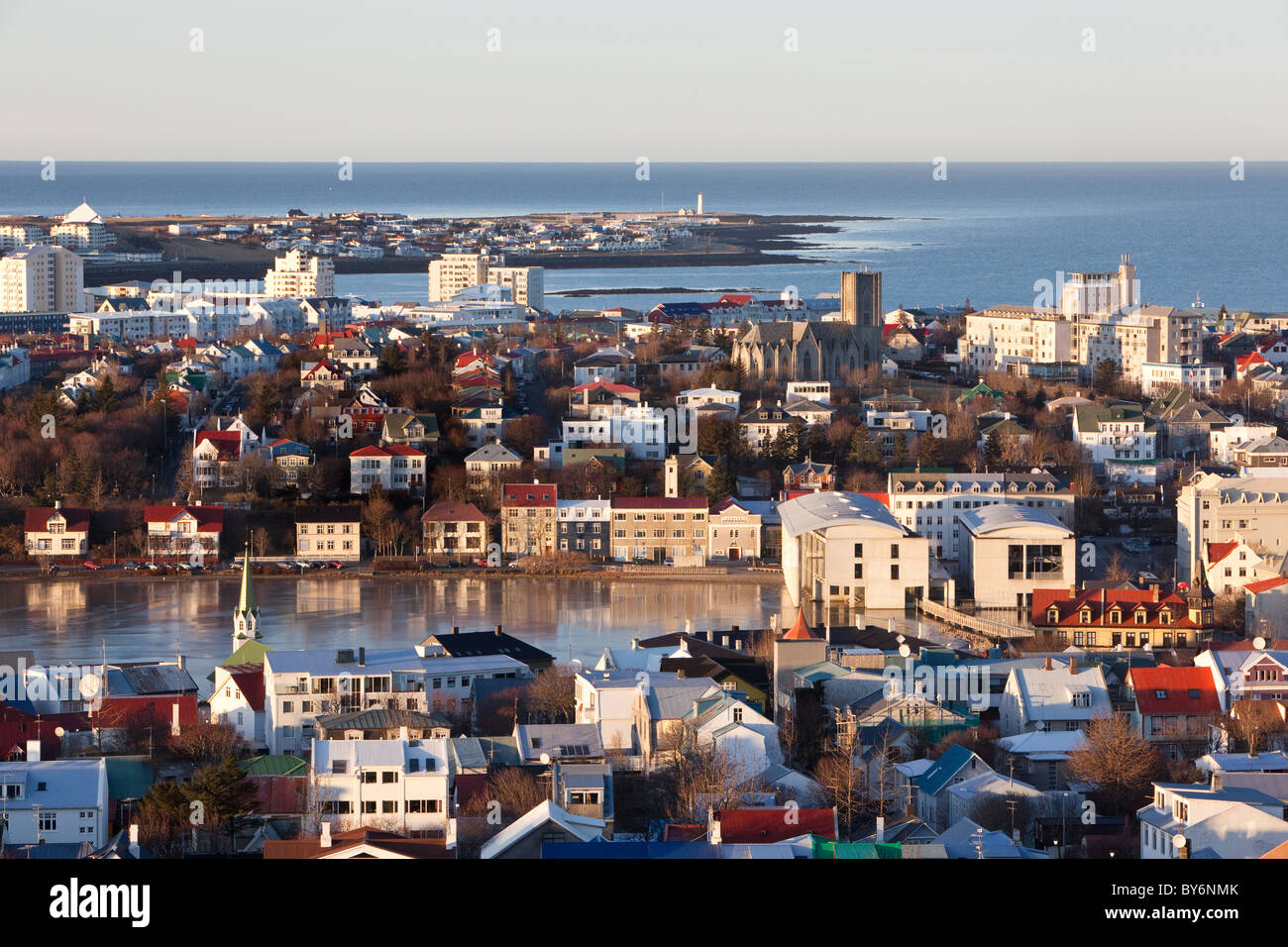 Una vista del centro della città di Reykjavík, Islanda, lo stagno (Tjörnin), tutti il modo in cui oltre al faro in Grótta. Foto Stock