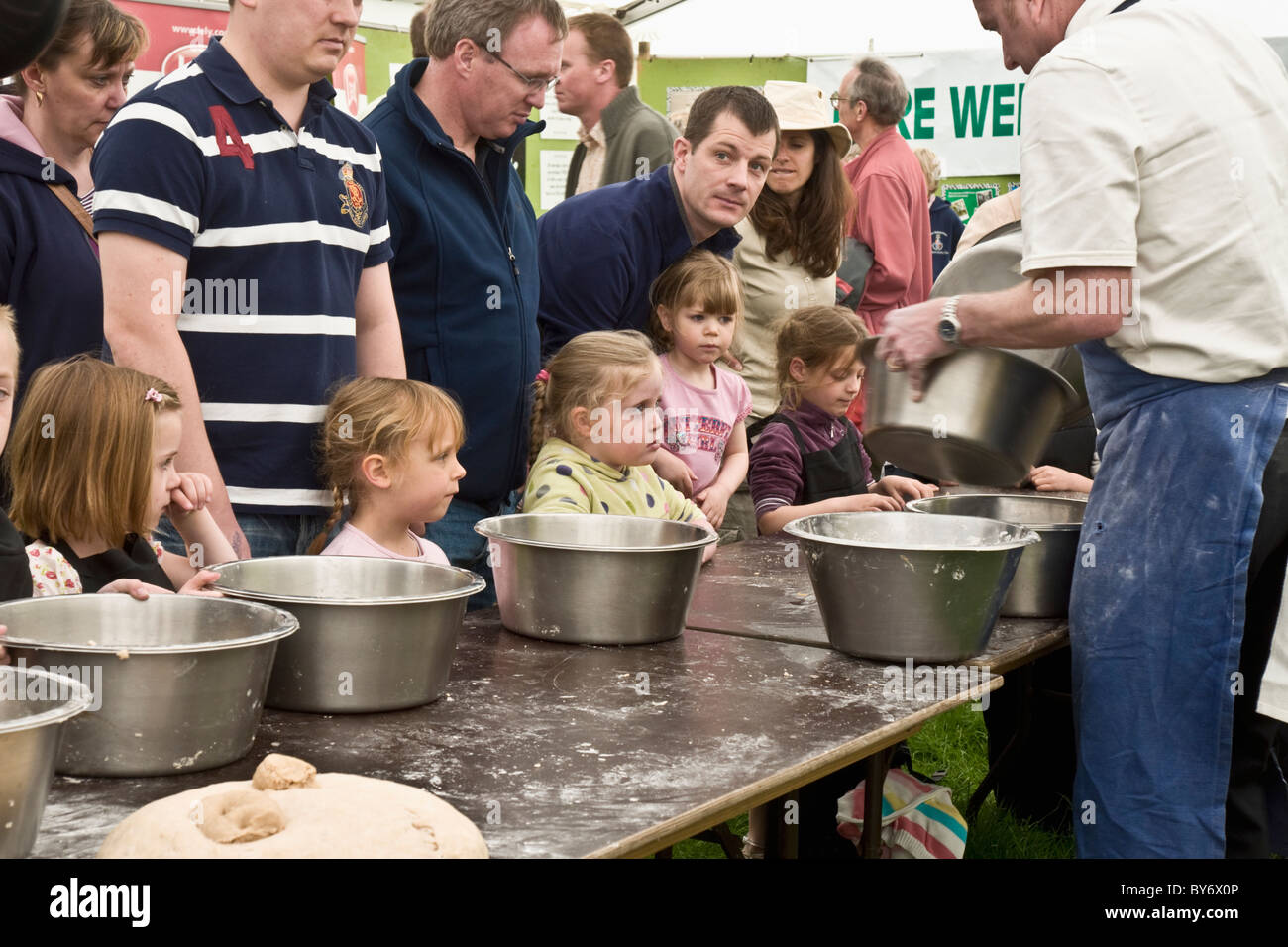 Un gruppo di bambini che cercano la loro mano a fare il pane al Festival annuale di cibo e bevande a Leyburn nel North Yorkshire Foto Stock